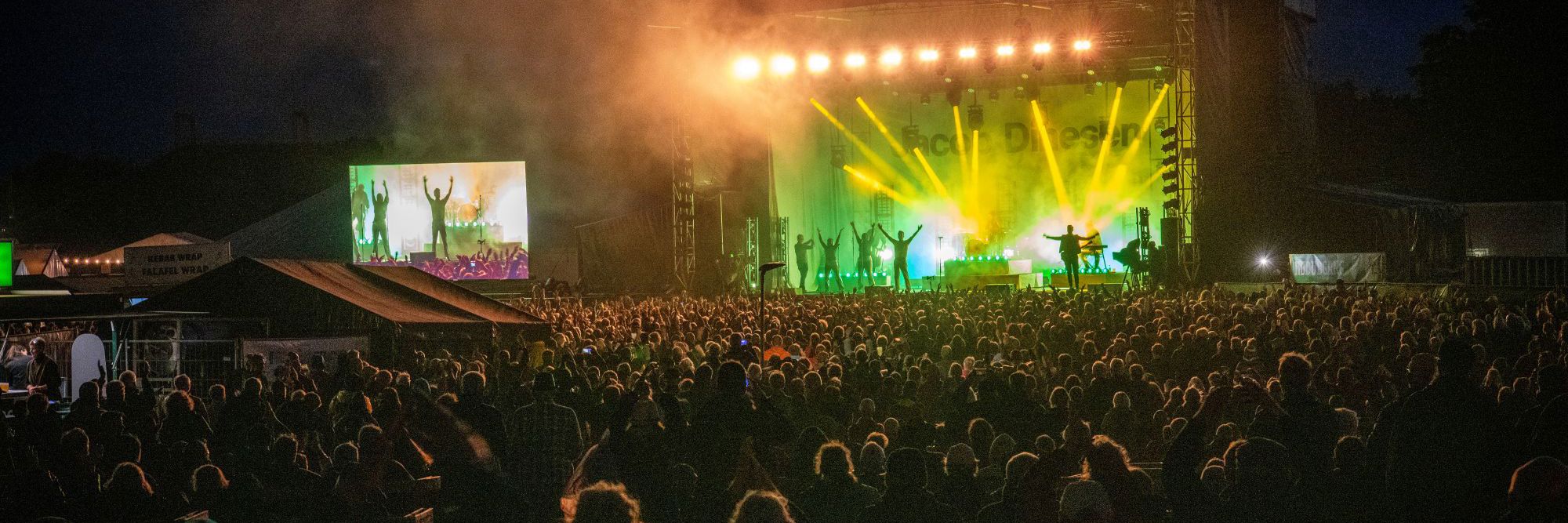 Mange mennesker står foran en scene og jubler til Tønder Festival