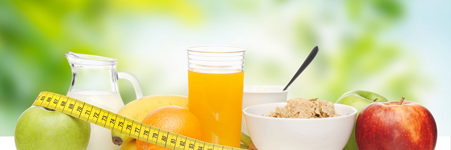 Morgenmad med et målbånd rundt om frugterne, juice, mælk og cornflakes