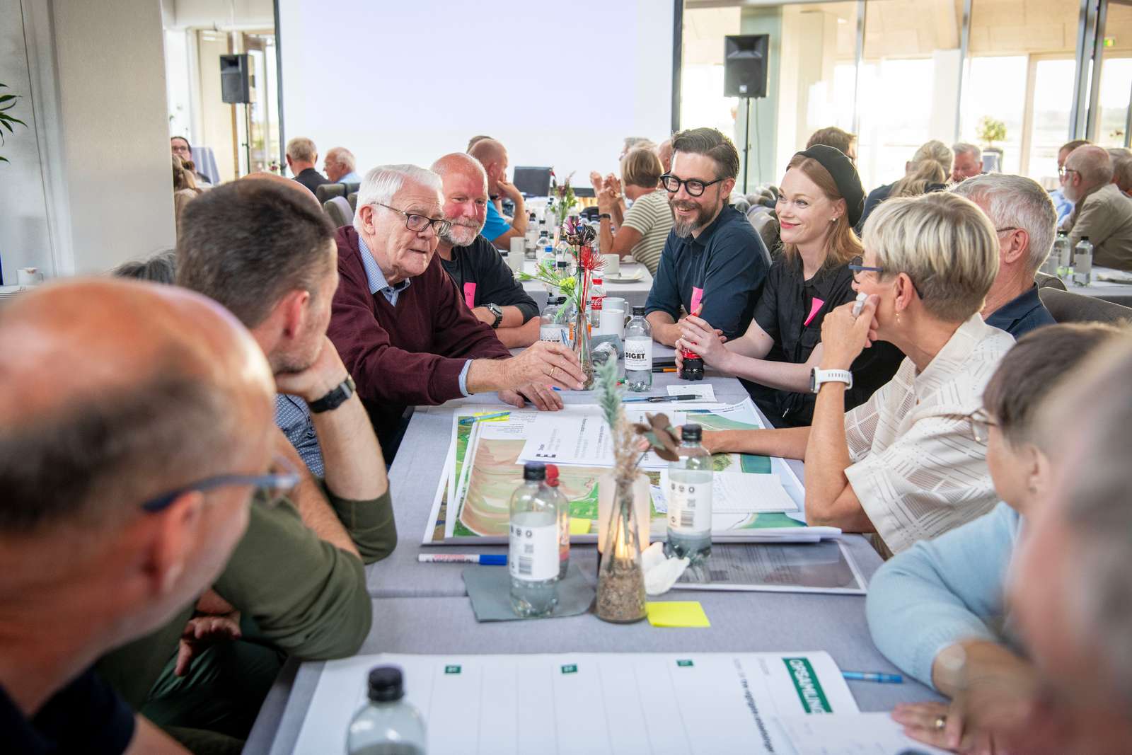 Folk der sidder sammen ved et bord og taler