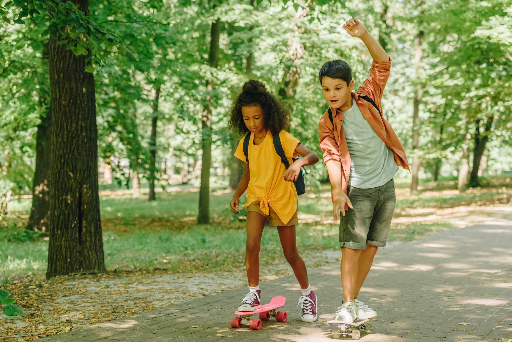 En pige og en dreng på skateboard