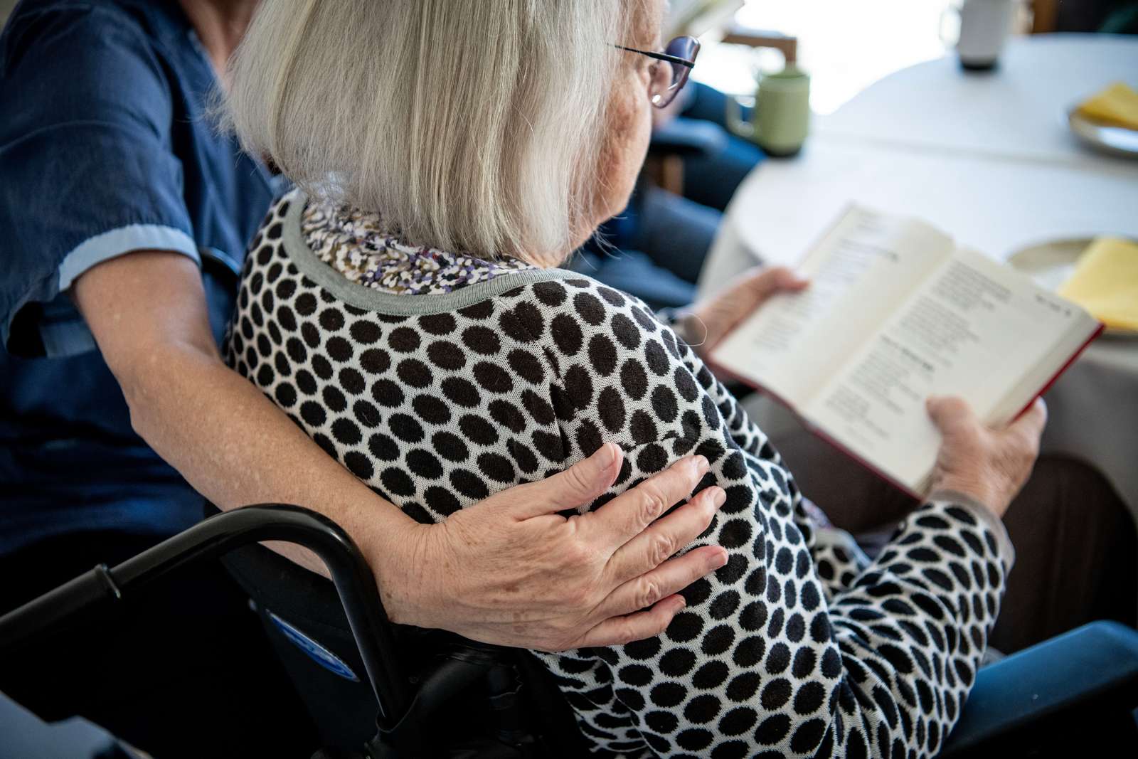 Medarbejder lægger arm omkring ældre borger