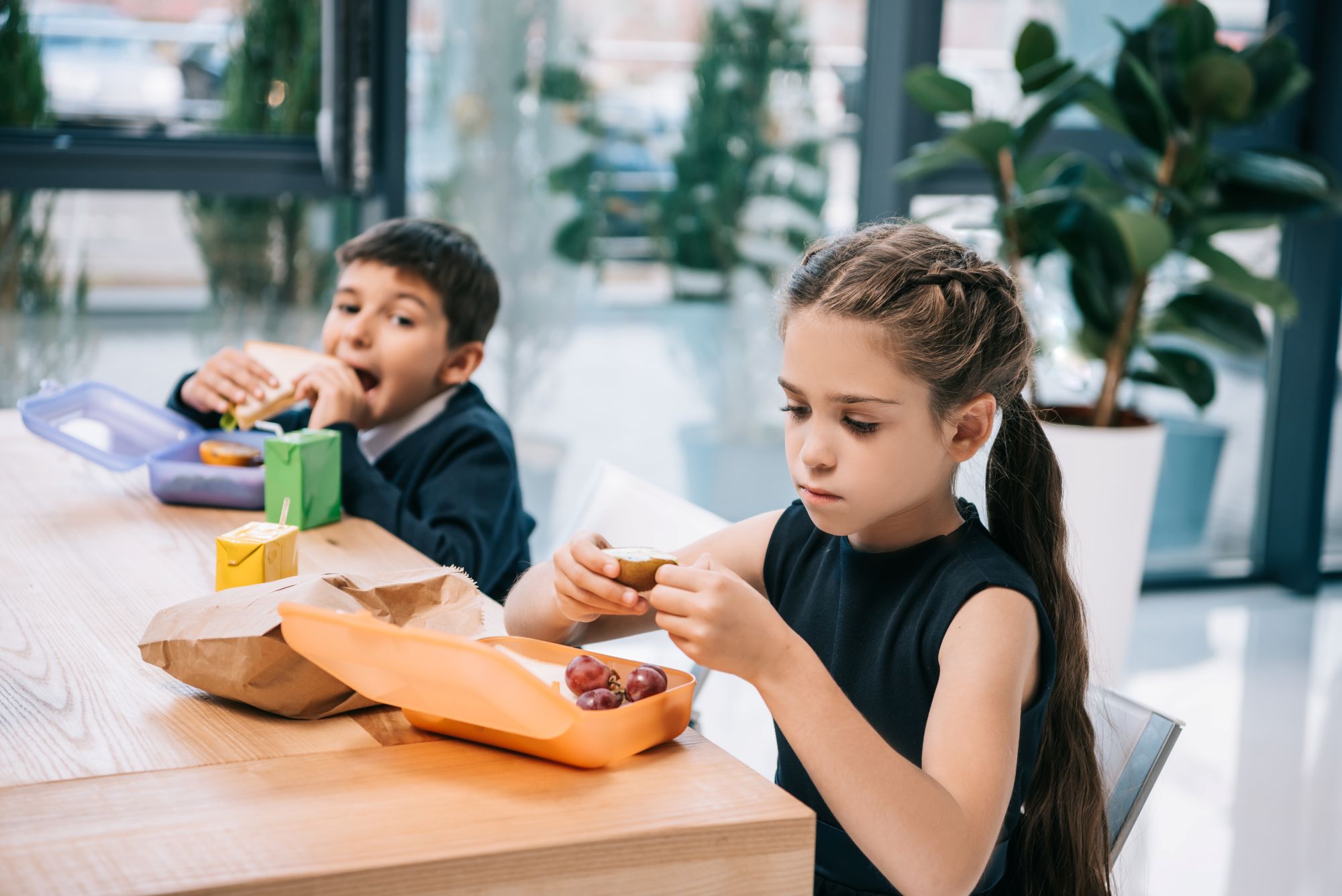 Dreng og pige i skolealderen spiser madpakker