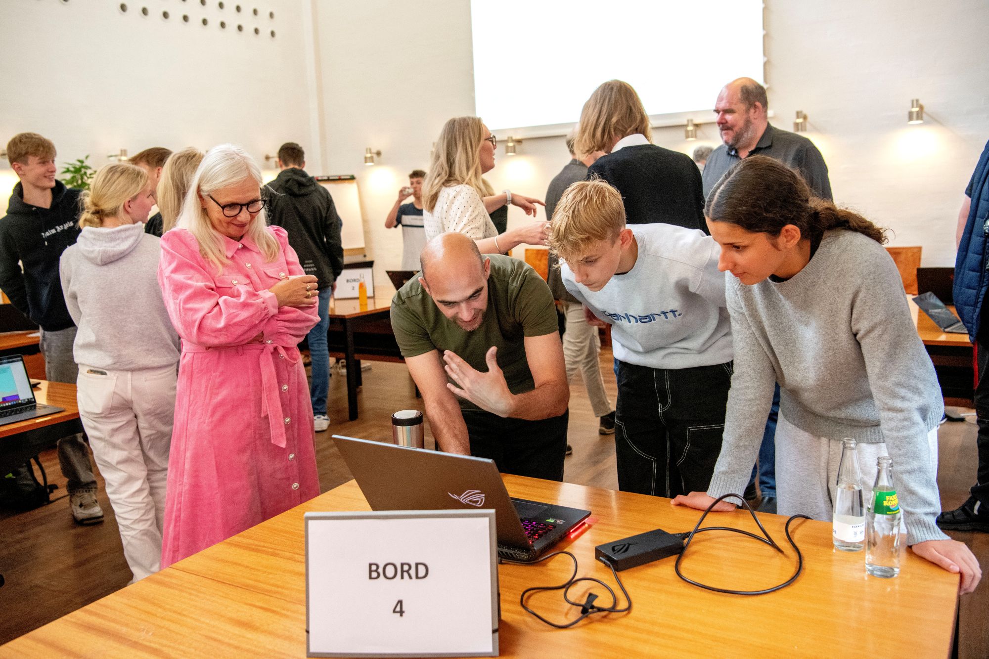 Unge og voksne kigger på en pc