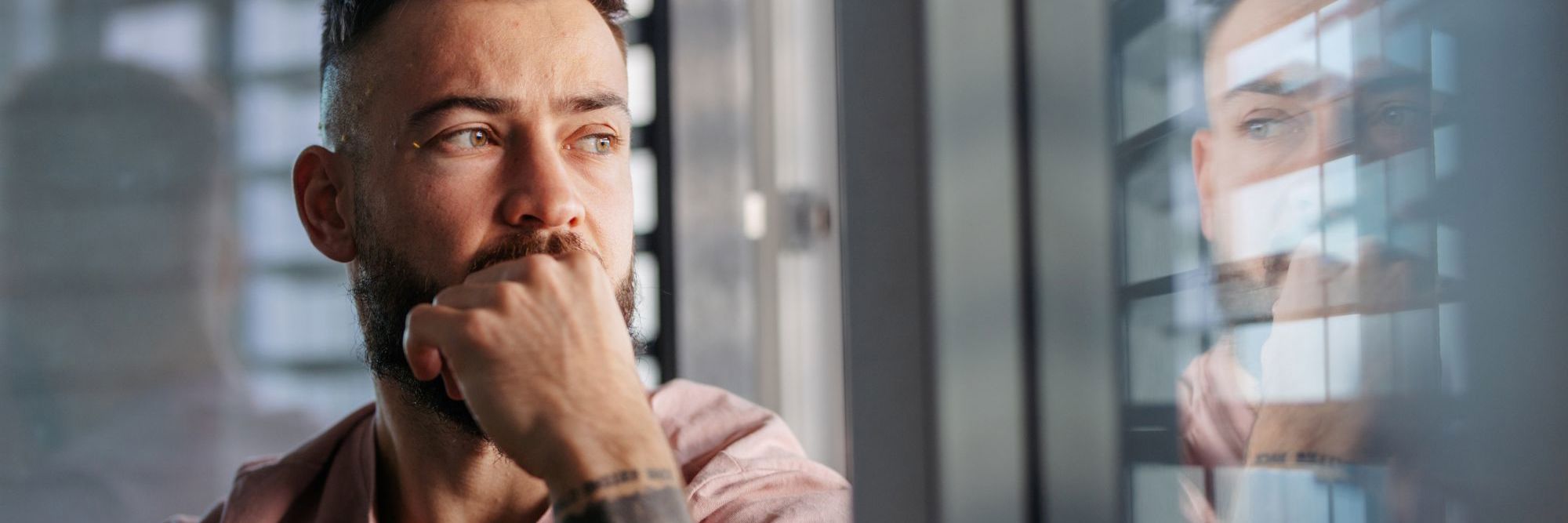 Mand ser trist ud og kigger ud ad vinduet
