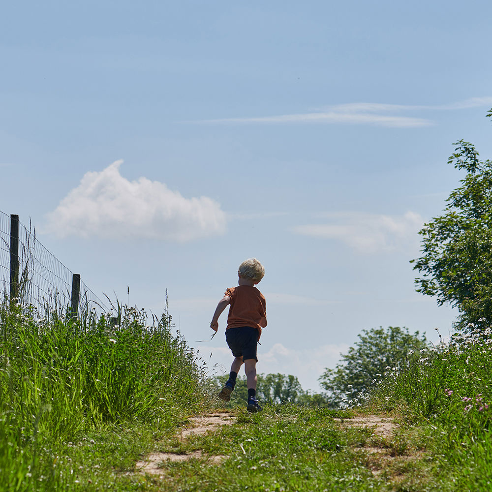 Dreng der løber på en marksti